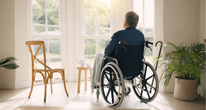Person in wheelchair gazing out window.