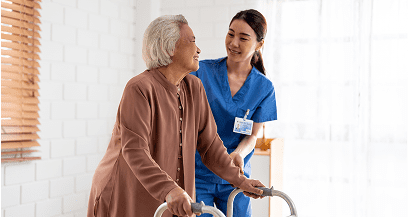 Elderly woman using walker with nurse's help.